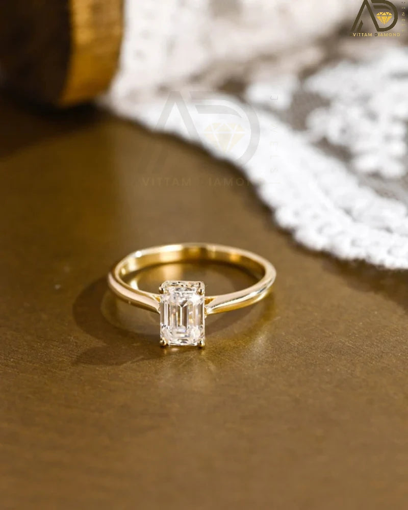 Discover our vintage style Emerald Cut Moissanite Solitaire Ring, designed to evoke timeless elegance. Perfect for engagements or as a unique gift for her.