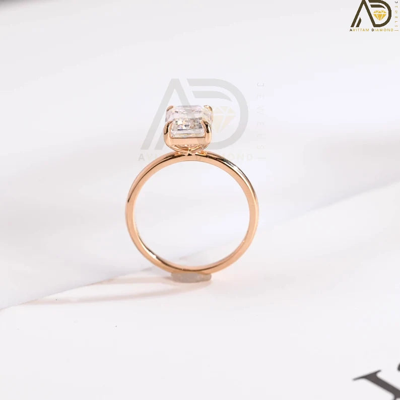 Elegant emerald cut moissanite ring with four sharp claws in solid rose gold, a timeless engagement, promise, or anniversary gift for her.