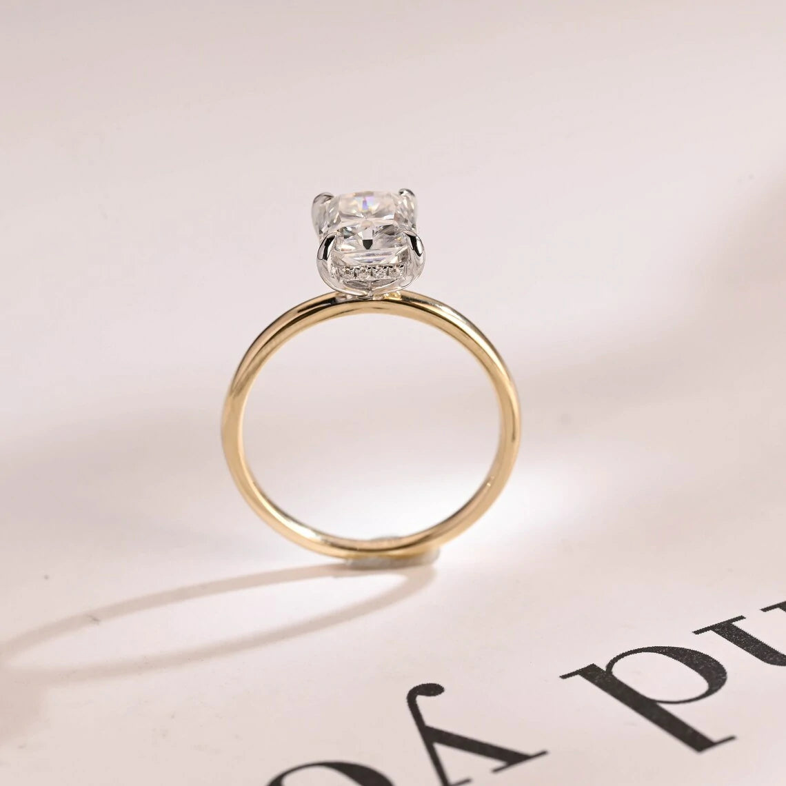 Stunning moissanite solitaire ring with radiant cut stone in yellow gold. Features a hidden halo for subtle glam and brilliant shine.