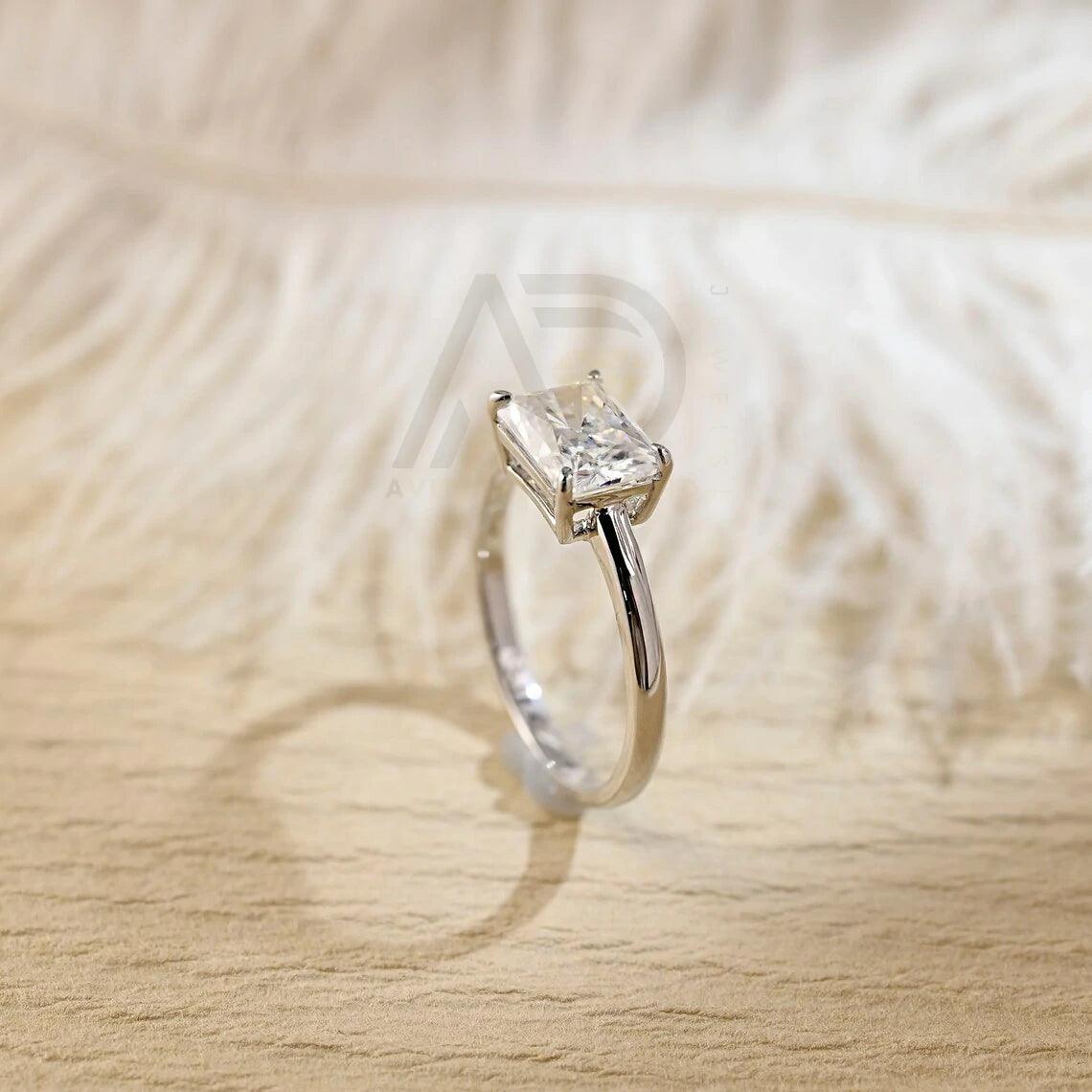 Discover elegance with our West to East Radiant Cut Solitaire Moissanite Engagement Ring. Crafted with a 3.00-carat radiant-cut moissanite diamond, Perfect for weddings or anniversaries. Shop now!