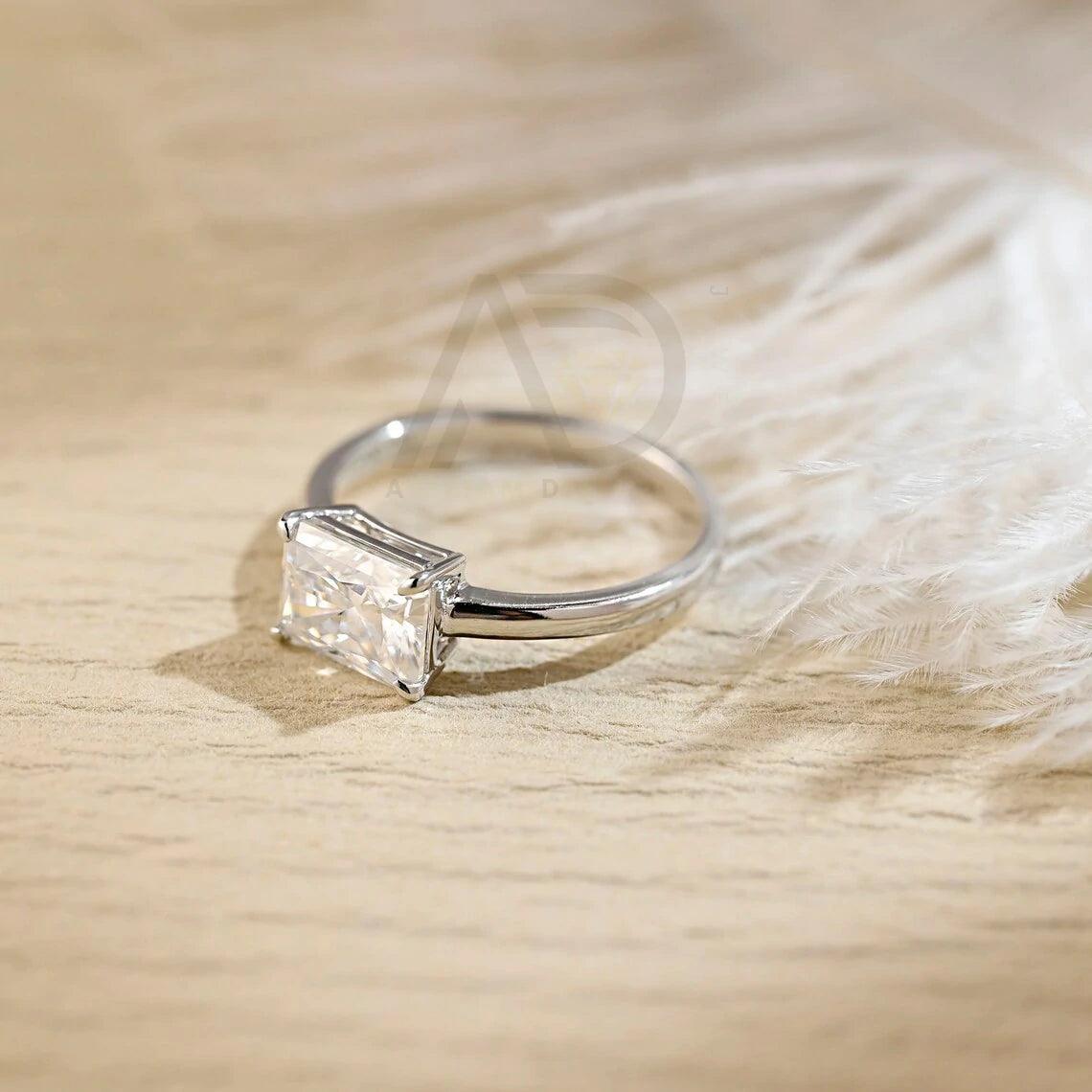 Discover elegance with our West to East Radiant Cut Solitaire Moissanite Engagement Ring. Crafted with a 3.00-carat radiant-cut moissanite diamond, Perfect for weddings or anniversaries. Shop now!