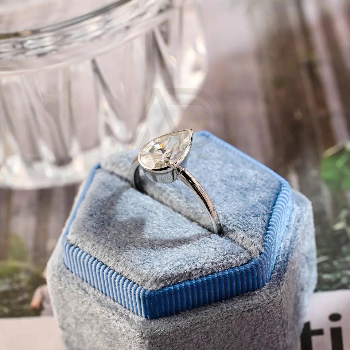 Shop the Pear Moissanite Solitaire Engagement Ring – Bezel Style for modern elegance, secure brilliance, and timeless sparkle in a refined and ethical engagement ring design.