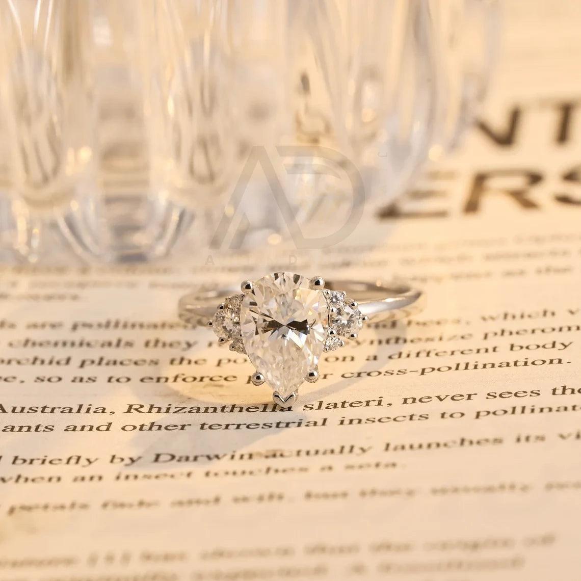 Pear Moissanite Engagement Ring, Teardrop Shaped Moissanite Ring, Round Accent Stone Ring, Solid Gold Promise Ring, Anniversary Gift for Women, Customizable Fine Jewelry, Unique Wedding Band, Luxurious Symbol of Love, Timeless Elegance, Romantic Anniversary Jewelry