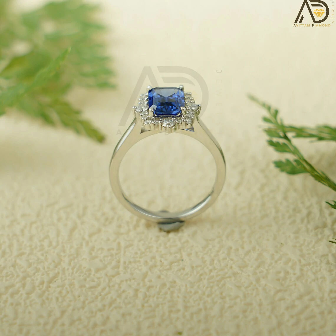 This luxurious handmade engagement ring features a vibrant emerald cut lab-grown sapphire in solid 10K, 14K, or 18K gold. Its unique cluster design is perfect for engagements, anniversaries, or special occasions.