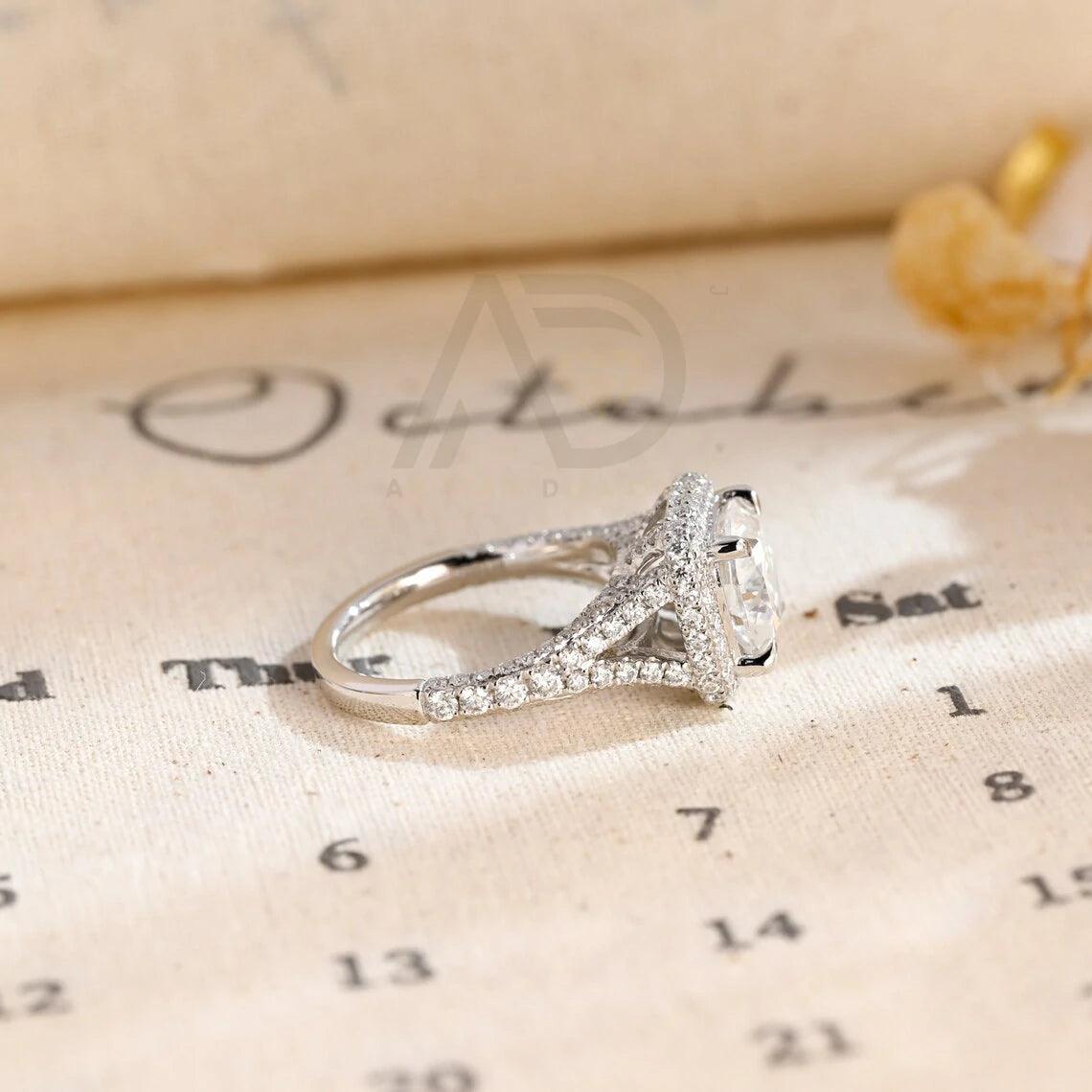 Vintage Cushion Cut Split Shank Moissanite Engagement Ring. This ring features a dazzling 3CT cushion cut moissanite diamond adorned with a halo design. Shop now!