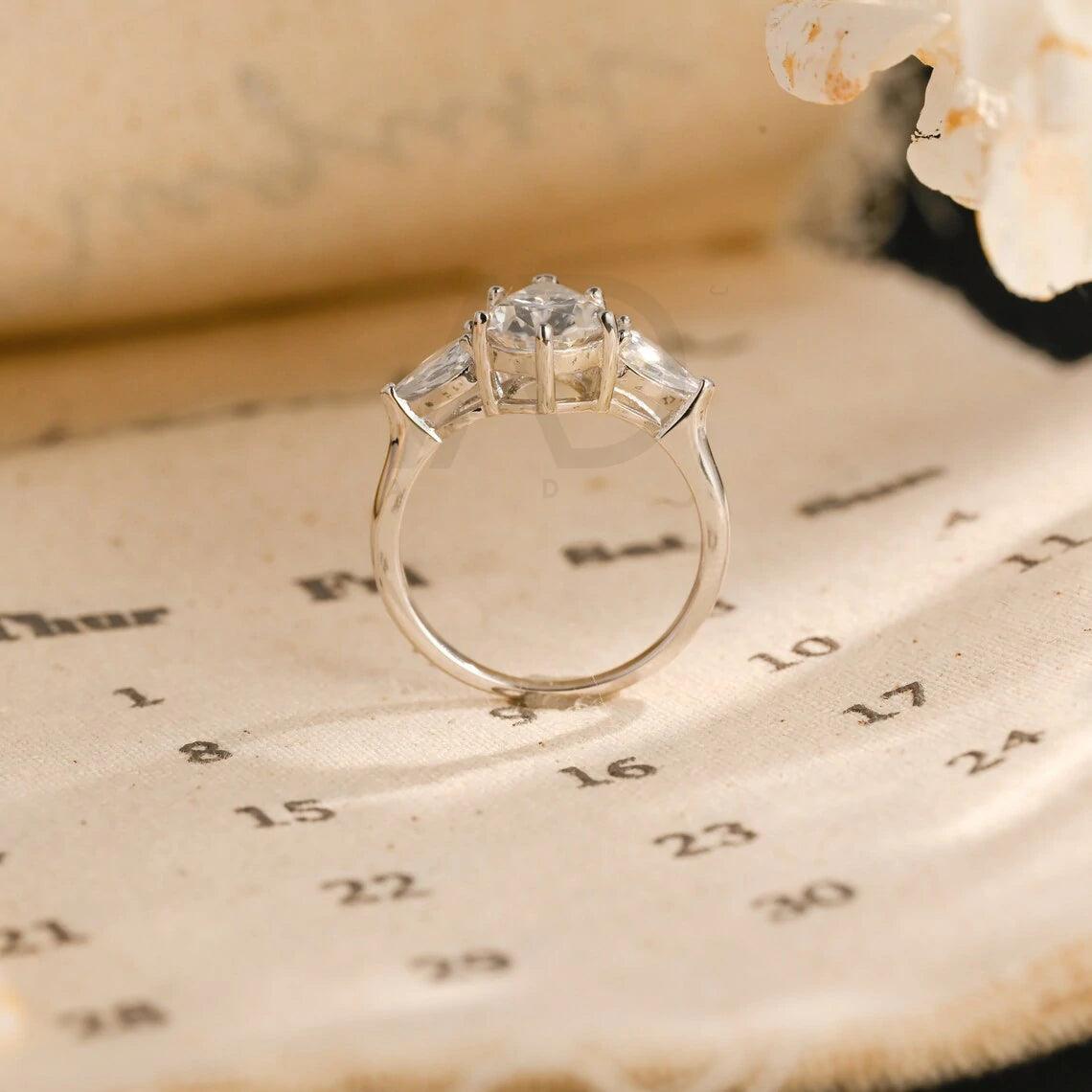 Pear Cut Three Stone Moissanite Engagement Ring. Perfect for weddings, promises, or anniversaries. Shop Now!