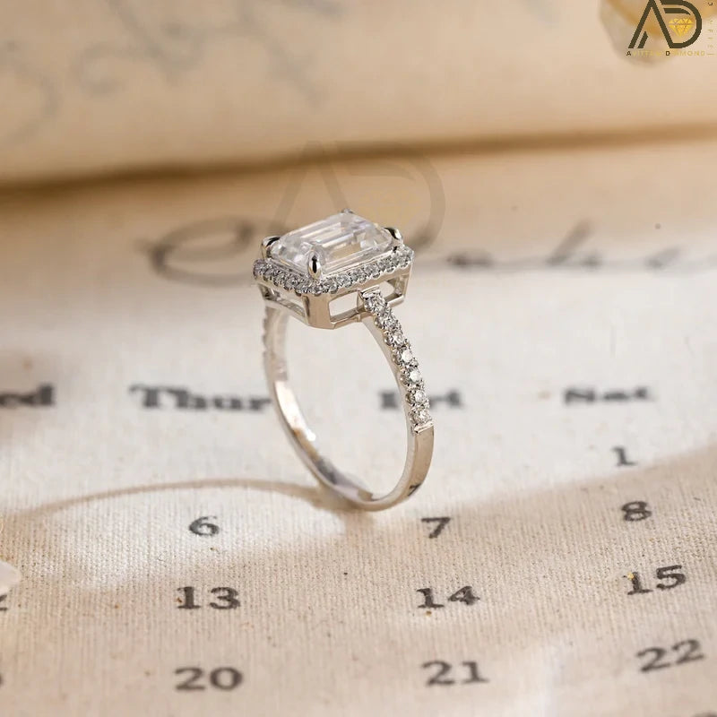 Discover the beauty of our emerald cut engagement ring with a halo of moissanite and a pave setting. Perfect for a dazzling and sophisticated bridal look.