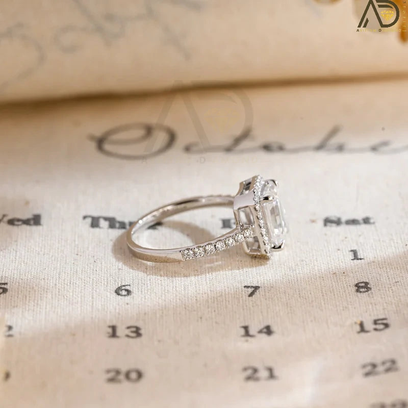 Discover the beauty of our emerald cut engagement ring with a halo of moissanite and a pave setting. Perfect for a dazzling and sophisticated bridal look.
