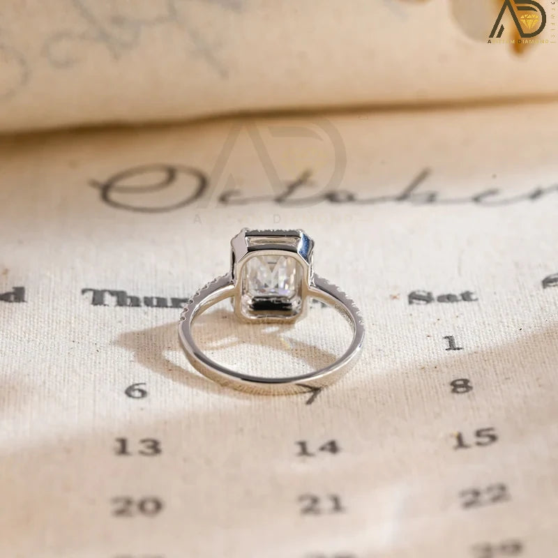Discover the beauty of our emerald cut engagement ring with a halo of moissanite and a pave setting. Perfect for a dazzling and sophisticated bridal look.