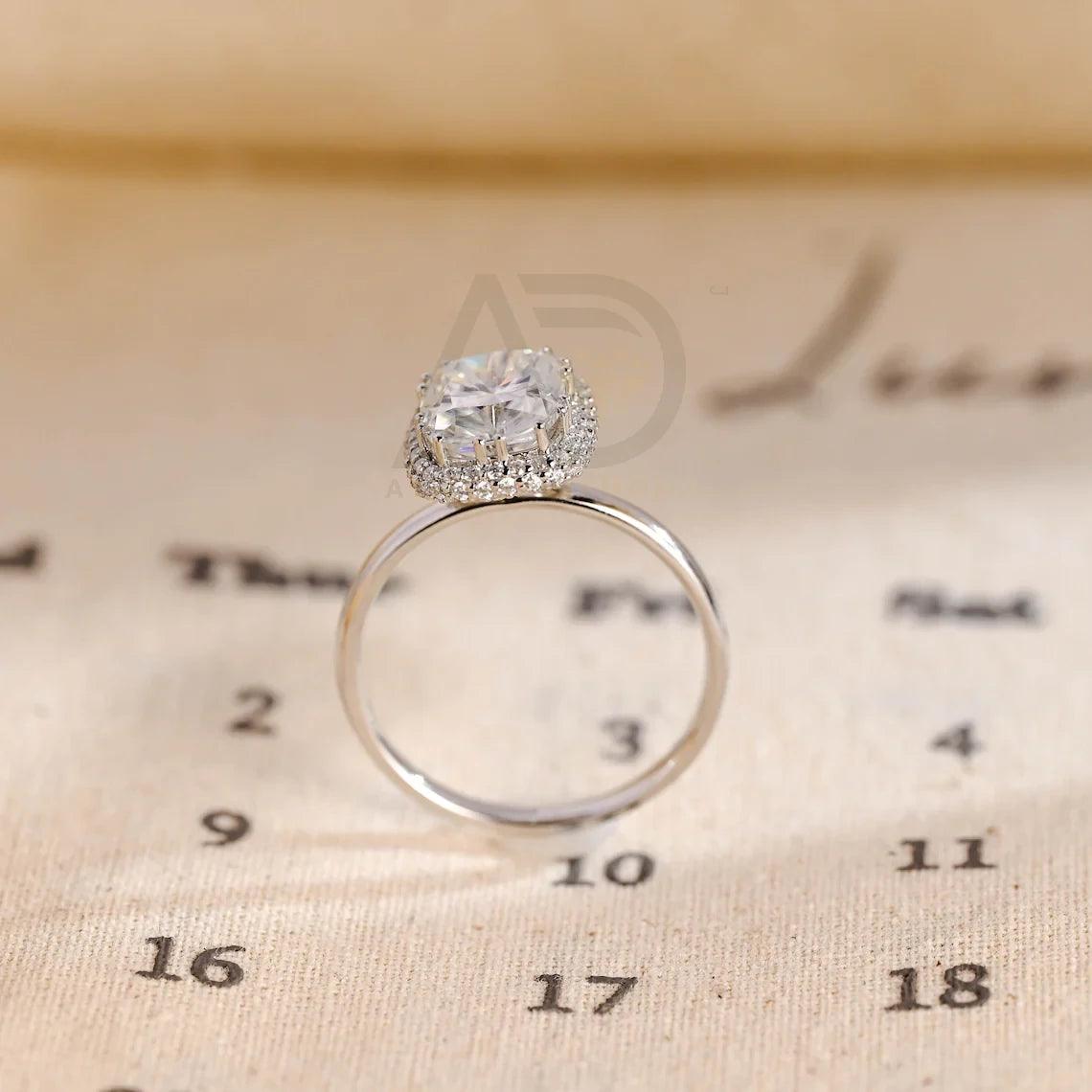 Halo Vintage Moissanite Engagement Ring. Crafted with precision, this ring features a 3Ct Moissanite Diamond in a Cushion Cut. Enjoy complimentary engraving and swift production. Shop now!