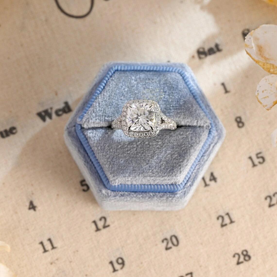 Vintage Cushion Cut Split Shank Moissanite Engagement Ring. This ring features a dazzling 3CT cushion cut moissanite diamond adorned with a halo design. Shop now!