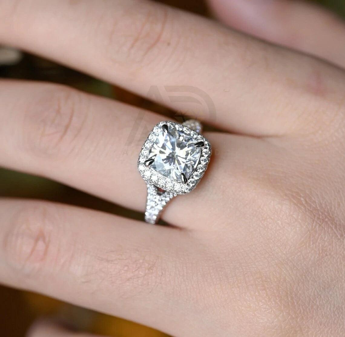 Vintage Cushion Cut Split Shank Moissanite Engagement Ring. This ring features a dazzling 3CT cushion cut moissanite diamond adorned with a halo design. Shop now!