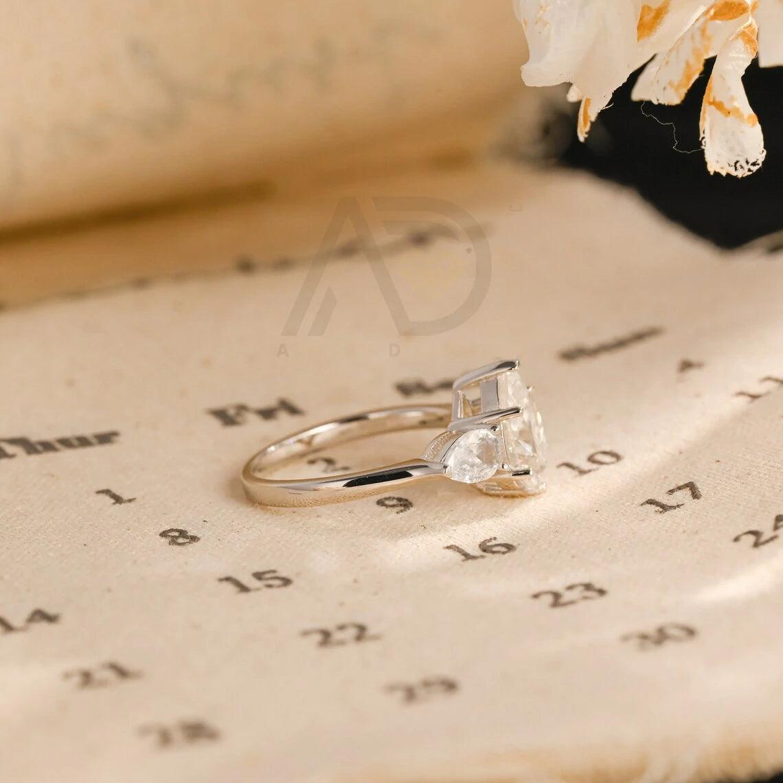 Pear Cut Three Stone Moissanite Engagement Ring. Perfect for weddings, promises, or anniversaries. Shop Now!