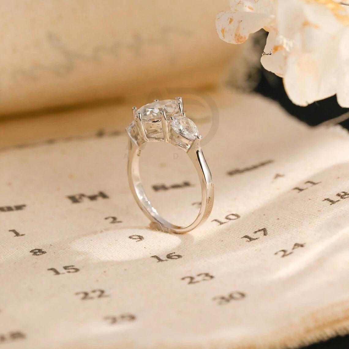 Pear Cut Three Stone Moissanite Engagement Ring. Perfect for weddings, promises, or anniversaries. Shop Now!
