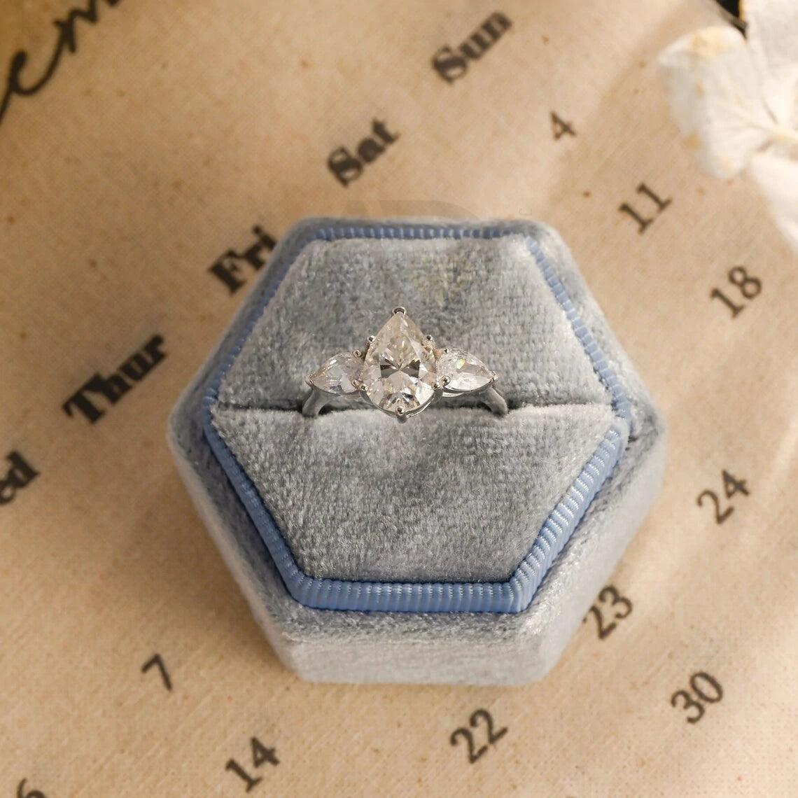 Pear Cut Three Stone Moissanite Engagement Ring. Perfect for weddings, promises, or anniversaries. Shop Now!