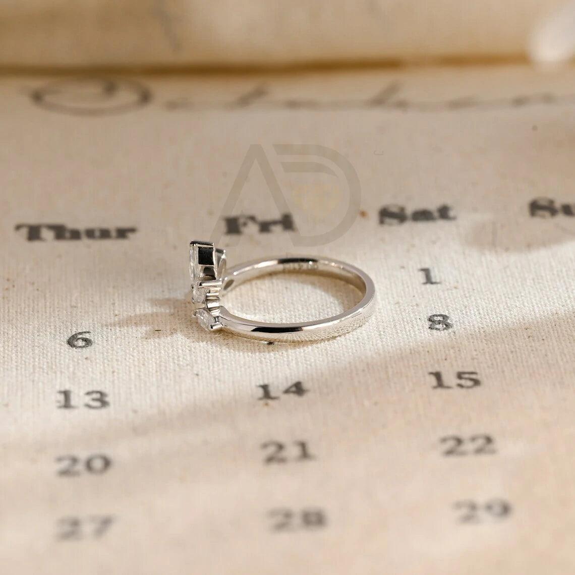 marquise wedding band, moissanite ring, wedding jewelry, bridal band, diamond alternative, anniversary gift, gold band, silver band, platinum band, handcrafted ring, dainty jewelry, elegant design, timeless beauty, luxury ring, custom made, fine jewelry, sparkling gemstone, modern elegance, statement piece, designer band, unique design, high-quality craftsmanship, affordable luxury