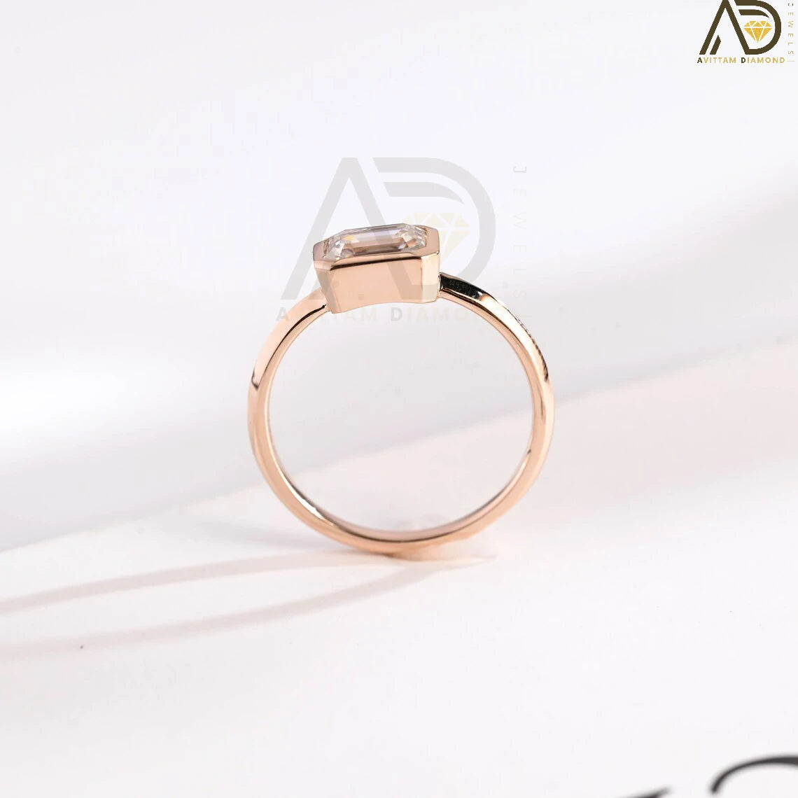 Celebrate your love with this solid gold East to West emerald cut moissanite engagement ring. Ideal for proposals, promises, anniversaries, or Christmas gifts. A stunning, timeless design for her.