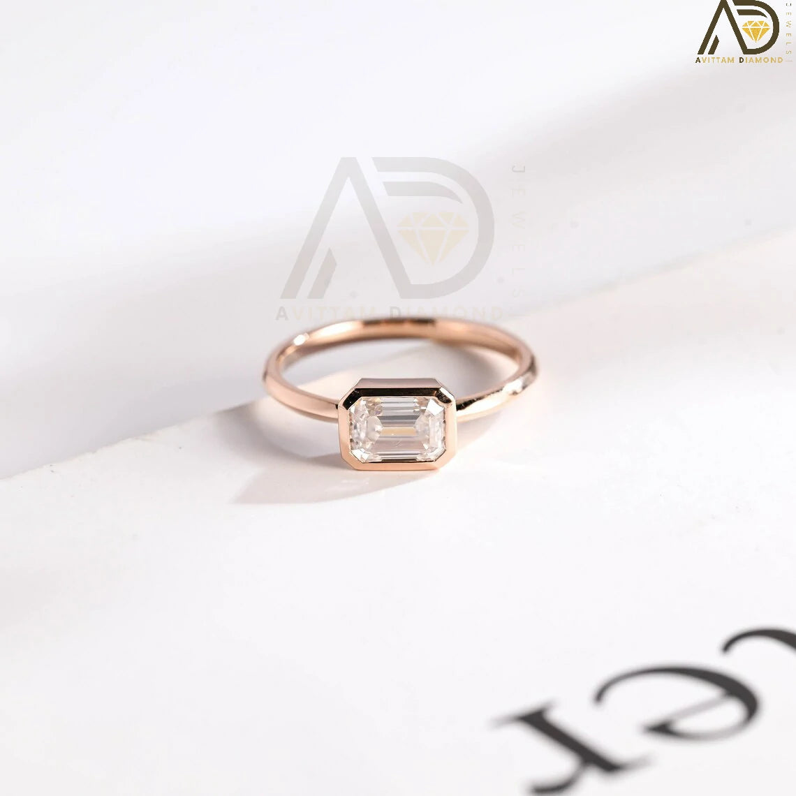 Celebrate your love with this solid gold East to West emerald cut moissanite engagement ring. Ideal for proposals, promises, anniversaries, or Christmas gifts. A stunning, timeless design for her.