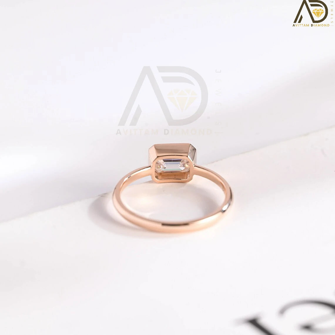 Celebrate your love with this solid gold East to West emerald cut moissanite engagement ring. Ideal for proposals, promises, anniversaries, or Christmas gifts. A stunning, timeless design for her.