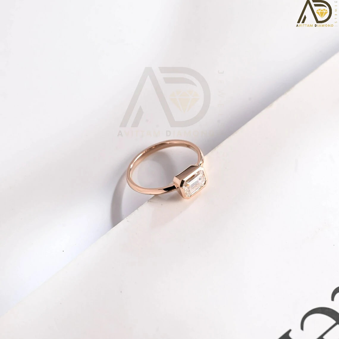 Celebrate your love with this solid gold East to West emerald cut moissanite engagement ring. Ideal for proposals, promises, anniversaries, or Christmas gifts. A stunning, timeless design for her.