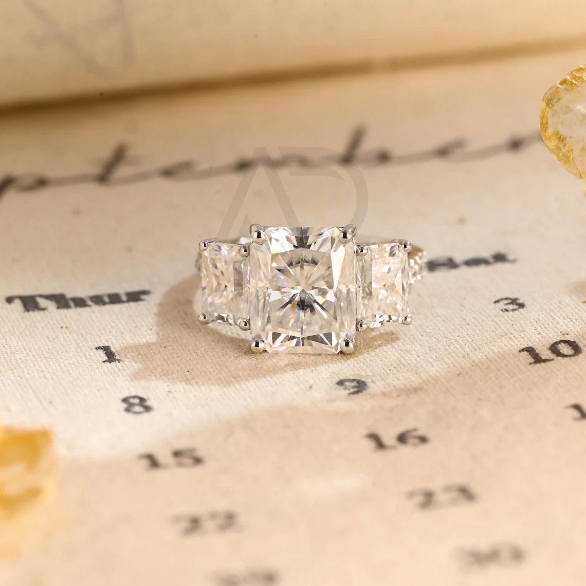 Delve into elegance and craftsmanship with our selection of Moissanite Engagement Rings, including radiant cut designs and Three Stone Wedding bands in Solid Gold. Celebrate your journey with a symbol as enduring as your love.
