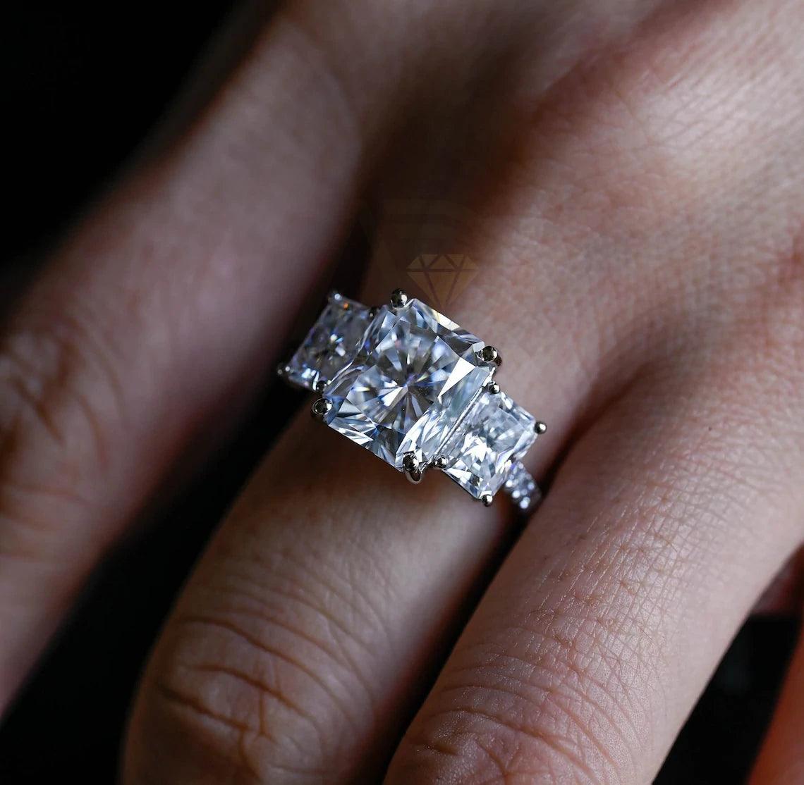 Delve into elegance and craftsmanship with our selection of Moissanite Engagement Rings, including radiant cut designs and Three Stone Wedding bands in Solid Gold. Celebrate your journey with a symbol as enduring as your love.