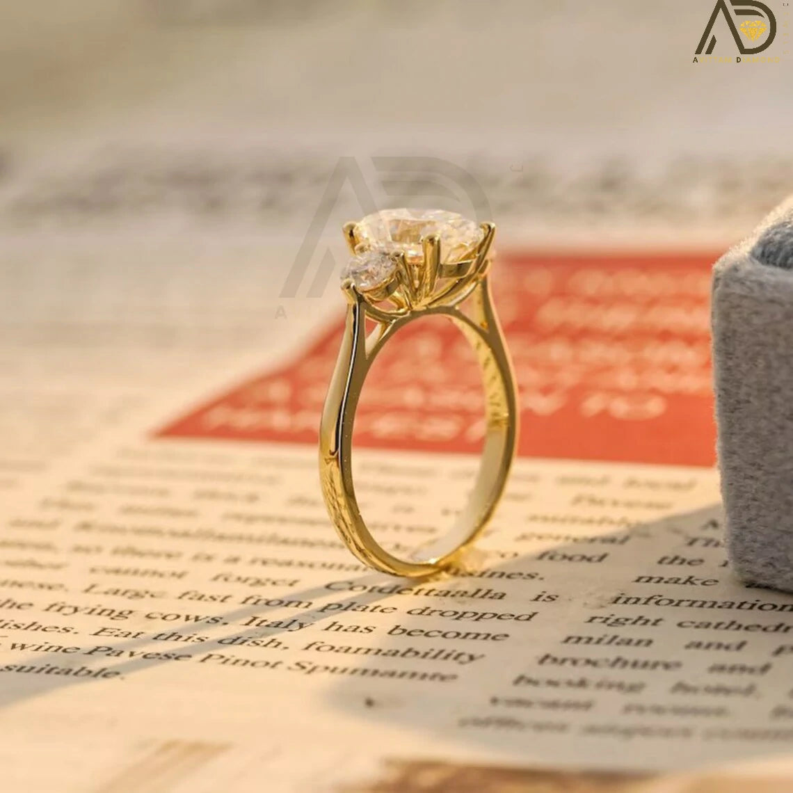 Discover our stunning Three Stone Moissanite Ring featuring an oval cut center and round side stones. Perfect for a unique engagement or wedding ring, this elegant piece showcases high-quality craftsmanship.