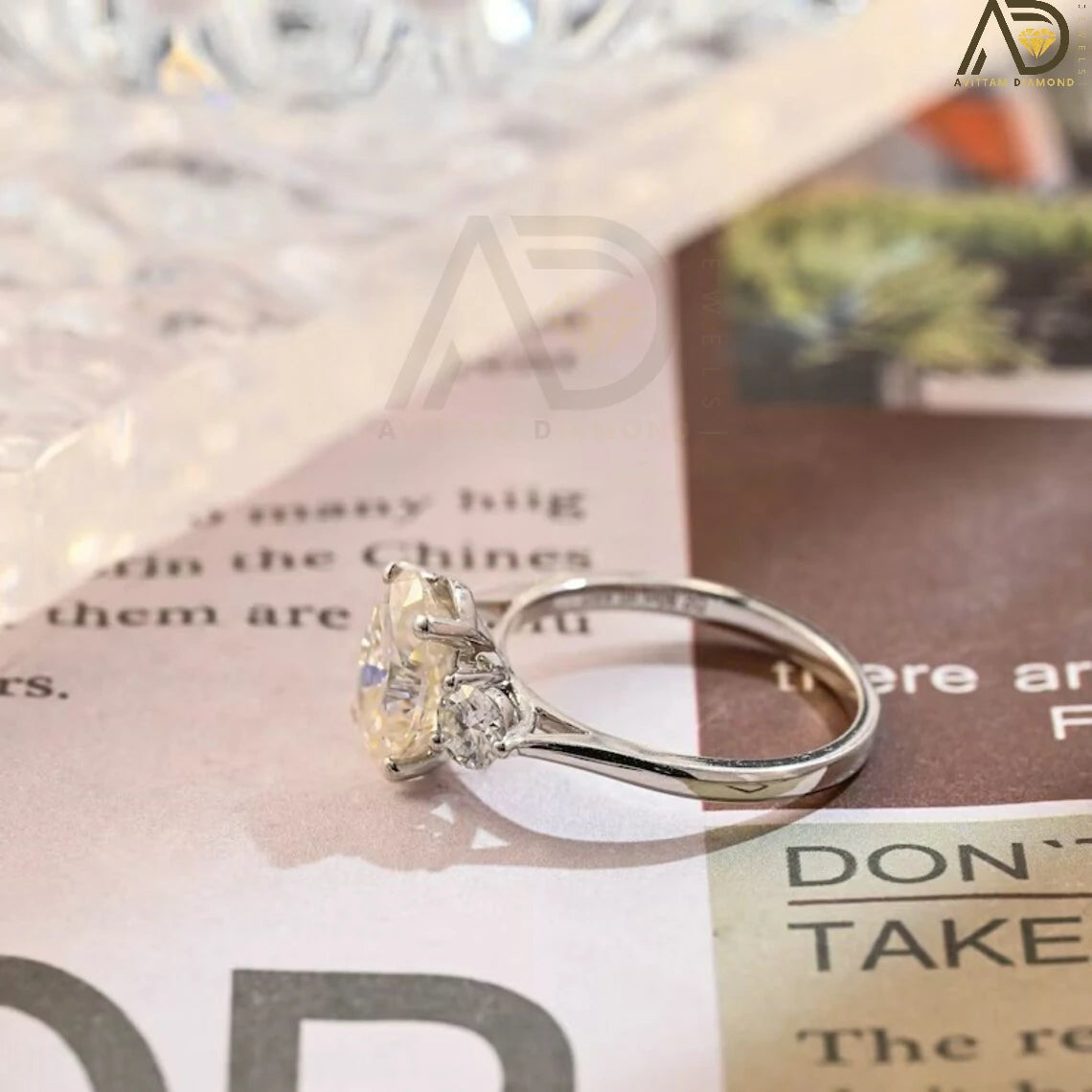 Discover our stunning Three Stone Moissanite Ring featuring an oval cut center and round side stones. Perfect for a unique engagement or wedding ring, this elegant piece showcases high-quality craftsmanship.