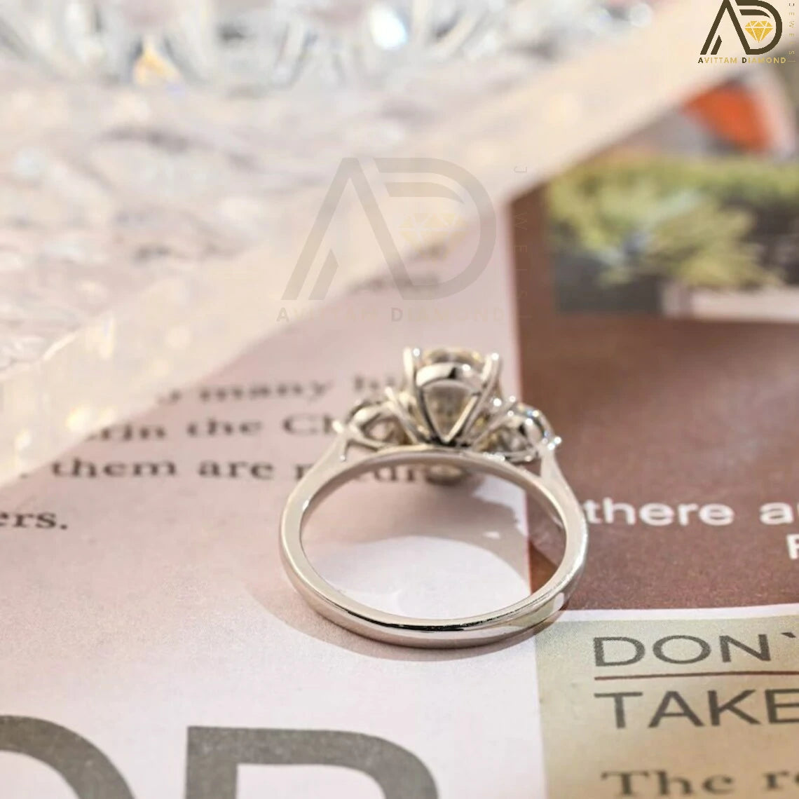 Discover our stunning Three Stone Moissanite Ring featuring an oval cut center and round side stones. Perfect for a unique engagement or wedding ring, this elegant piece showcases high-quality craftsmanship.