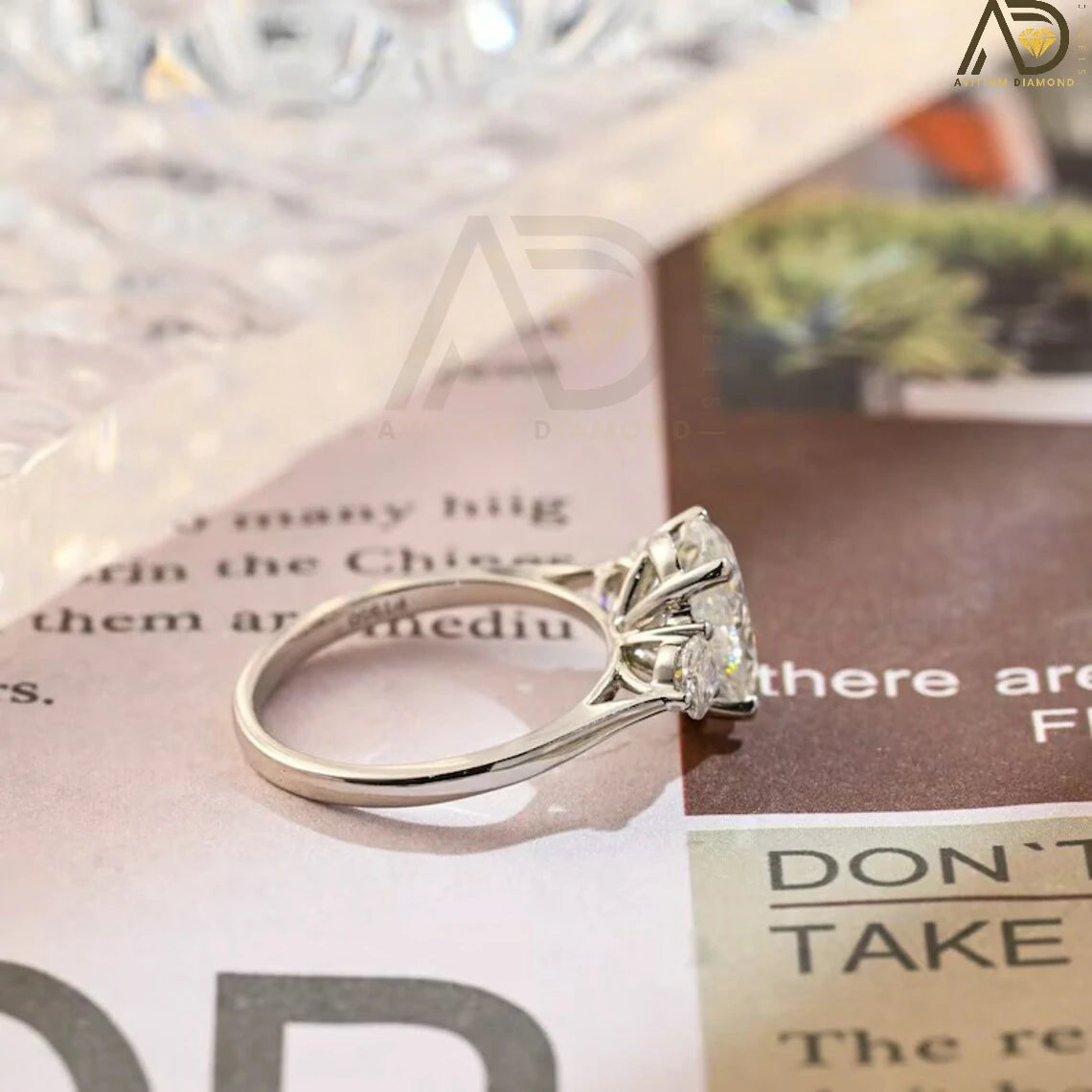Discover our stunning Three Stone Moissanite Ring featuring an oval cut center and round side stones. Perfect for a unique engagement or wedding ring, this elegant piece showcases high-quality craftsmanship.