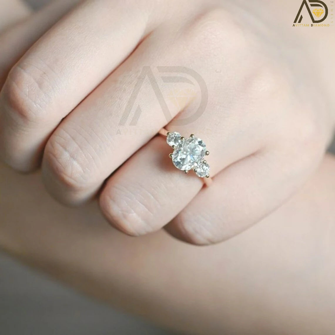 Discover our stunning Three Stone Moissanite Ring featuring an oval cut center and round side stones. Perfect for a unique engagement or wedding ring, this elegant piece showcases high-quality craftsmanship.