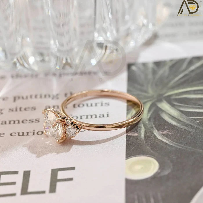 Discover our Three Stone Round Cut Moissanite Ring, a stunning choice for her engagement. Its elegant design and brilliance make it an unforgettable symbol of love.