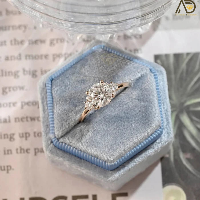 Discover our Three Stone Round Cut Moissanite Ring, a stunning choice for her engagement. Its elegant design and brilliance make it an unforgettable symbol of love.