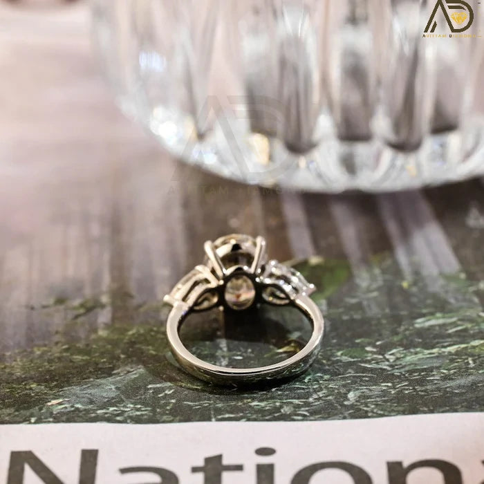 Discover our stunning Three Stone Moissanite Ring featuring an elegant oval cut center stone and pear cut side stones. A perfect choice for weddings or engagements!