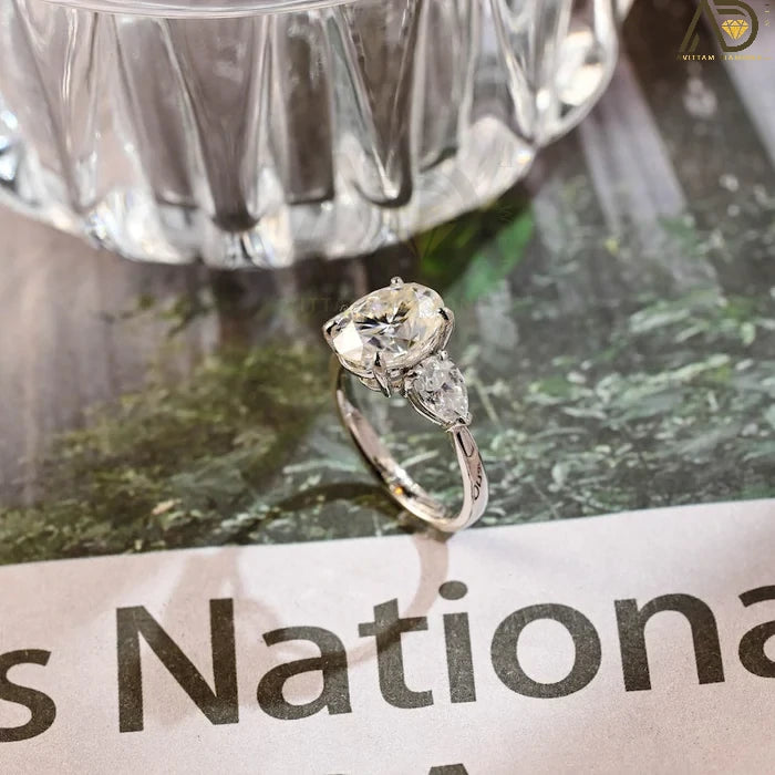 Discover our stunning Three Stone Moissanite Ring featuring an elegant oval cut center stone and pear cut side stones. A perfect choice for weddings or engagements!
