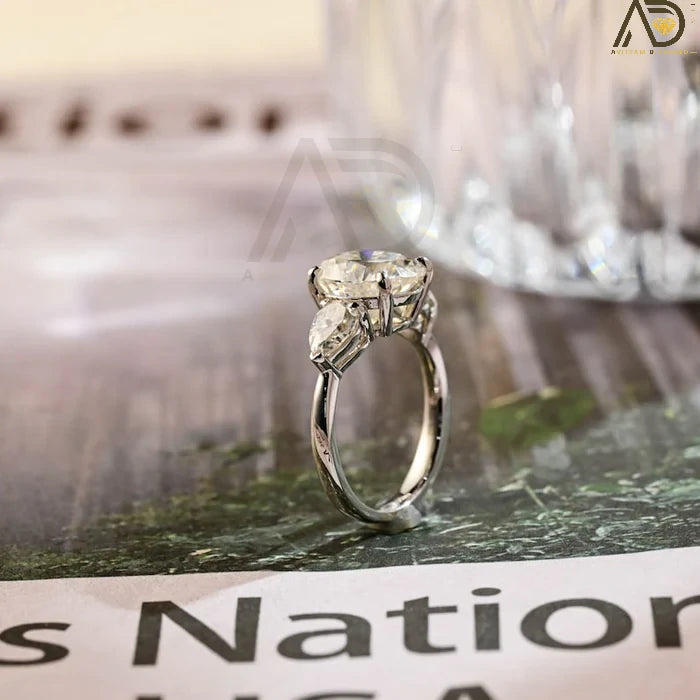 Discover our stunning Three Stone Moissanite Ring featuring an elegant oval cut center stone and pear cut side stones. A perfect choice for weddings or engagements!