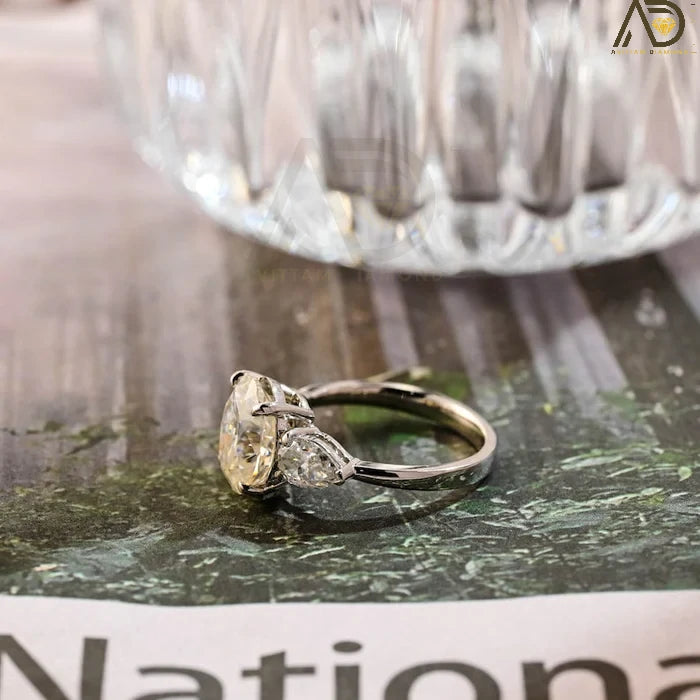Discover our stunning Three Stone Moissanite Ring featuring an elegant oval cut center stone and pear cut side stones. A perfect choice for weddings or engagements!