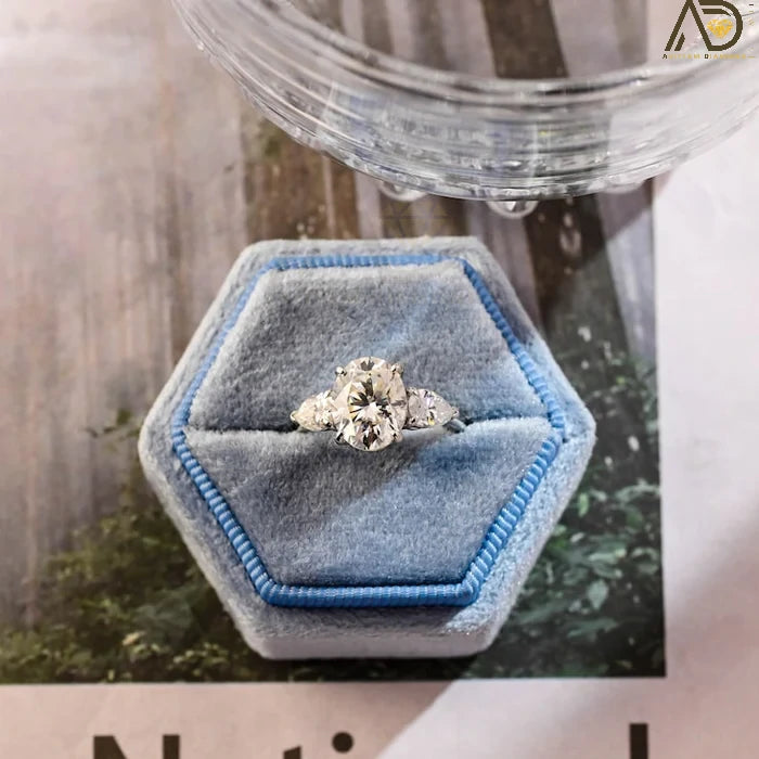 Discover our stunning Three Stone Moissanite Ring featuring an elegant oval cut center stone and pear cut side stones. A perfect choice for weddings or engagements!