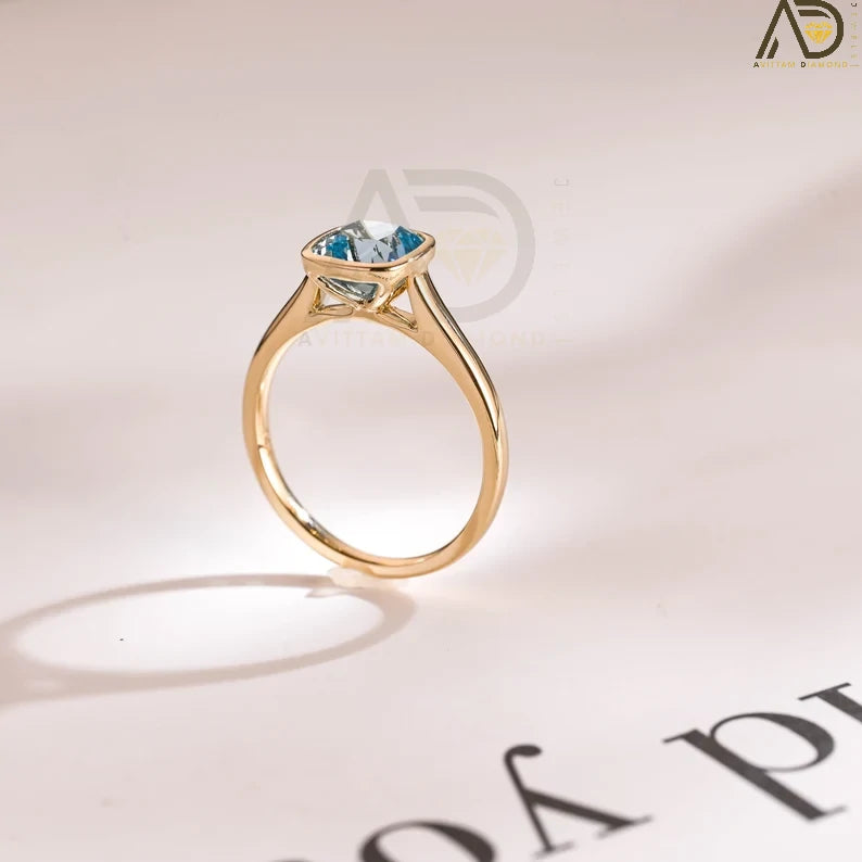 Discover our Solid Gold Cushion Cut Aquamarine Engagement Ring with a sleek bezel setting. Perfect as a proposal ring, promise ring, or anniversary gift for the special woman in your life.