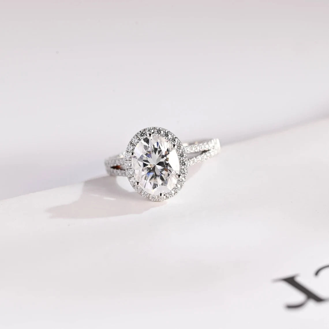 Oval Moissanite Three-Stone  Ring in yellow gold with sparkling round side stones. A timeless engagement and anniversary ring symbolizing past, present, and future love.