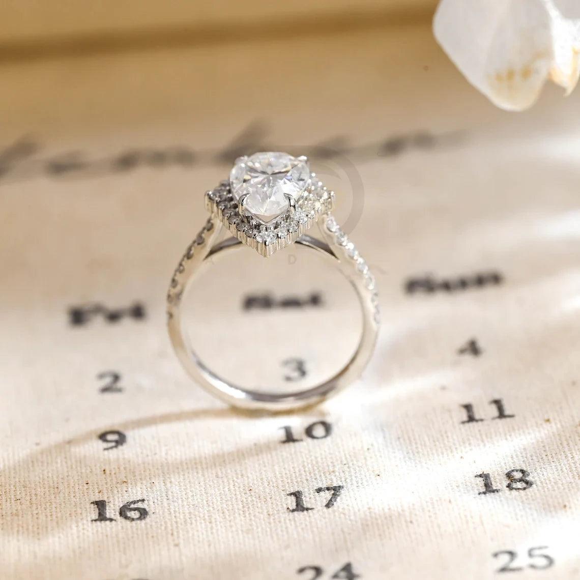 halo pear ring, pear engagement ring, pear halo ring, halo diamond ring, halo moissanite ring, pear cut ring, pear diamond ring, pear moissanite ring, halo bridal ring, pear wedding ring, halo promise ring, vintage pear ring, elegant pear ring, unique pear ring, classic pear ring, custom pear ring, gold pear ring, platinum pear ring, silver pear ring, pear eternity ring, pear three stone ring, halo anniversary ring, luxury pear ring, dainty pear ring, simple pear ring