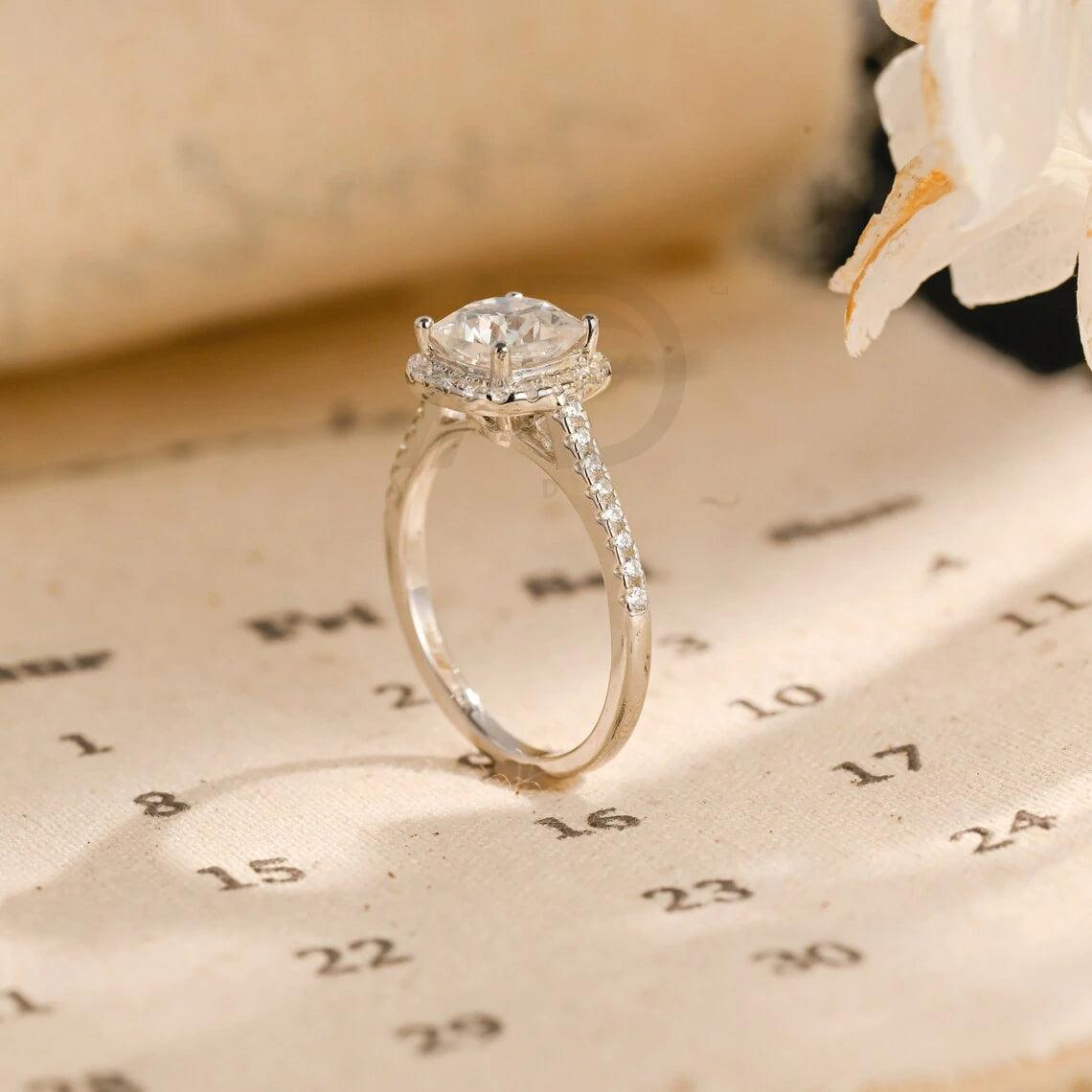 moissanite engagement, cushion diamond ring, halo diamond ring, cushion bridal ring, moissanite bridal ring, cushion wedding ring, halo wedding ring, cushion halo ring, moissanite cushion cut, elegant cushion ring, unique halo ring, vintage halo ring, classic cushion ring, custom cushion ring, gold cushion ring, platinum cushion ring, silver cushion ring, luxury cushion ring, simple cushion ring, anniversary cushion ring