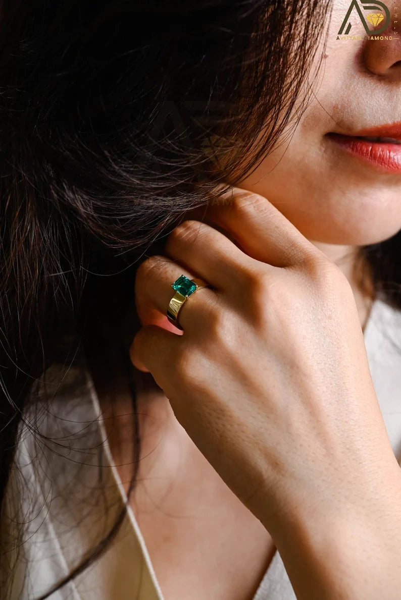 This elegant Solid Gold Lab Grown Emerald Ring features a wide band and minimalist design, ideal for proposals, anniversaries, or promises.

