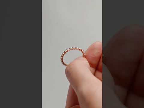 Elegant round cut moissanite eternity band crafted in rose gold. A timeless wedding or anniversary ring with continuous sparkle and luxury.