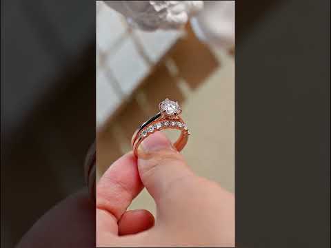 Round cut moissanite hidden halo bridal ring set in rose gold featuring a solitaire engagement ring and matching band. Elegant, timeless, and handcrafted.