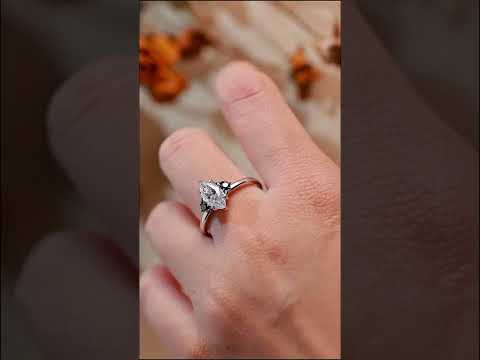 Marquise cut moissanite diamond solitaire ring with black diamond accents. A timeless prong-set engagement ring with bold contrast and elegant sparkle.