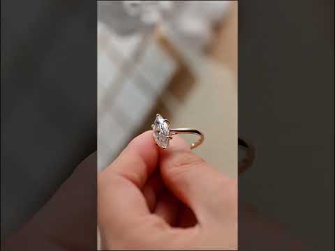 Marquise cut moissanite diamond engagement ring with prong-set solitaire and cathedral shank, handcrafted in solid gold for timeless elegance.