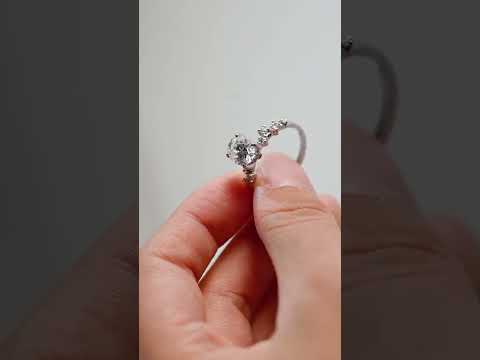 Oval cut moissanite ring with hidden halo and cluster side diamonds. A dazzling straight shank engagement ring crafted for timeless beauty and brilliance.